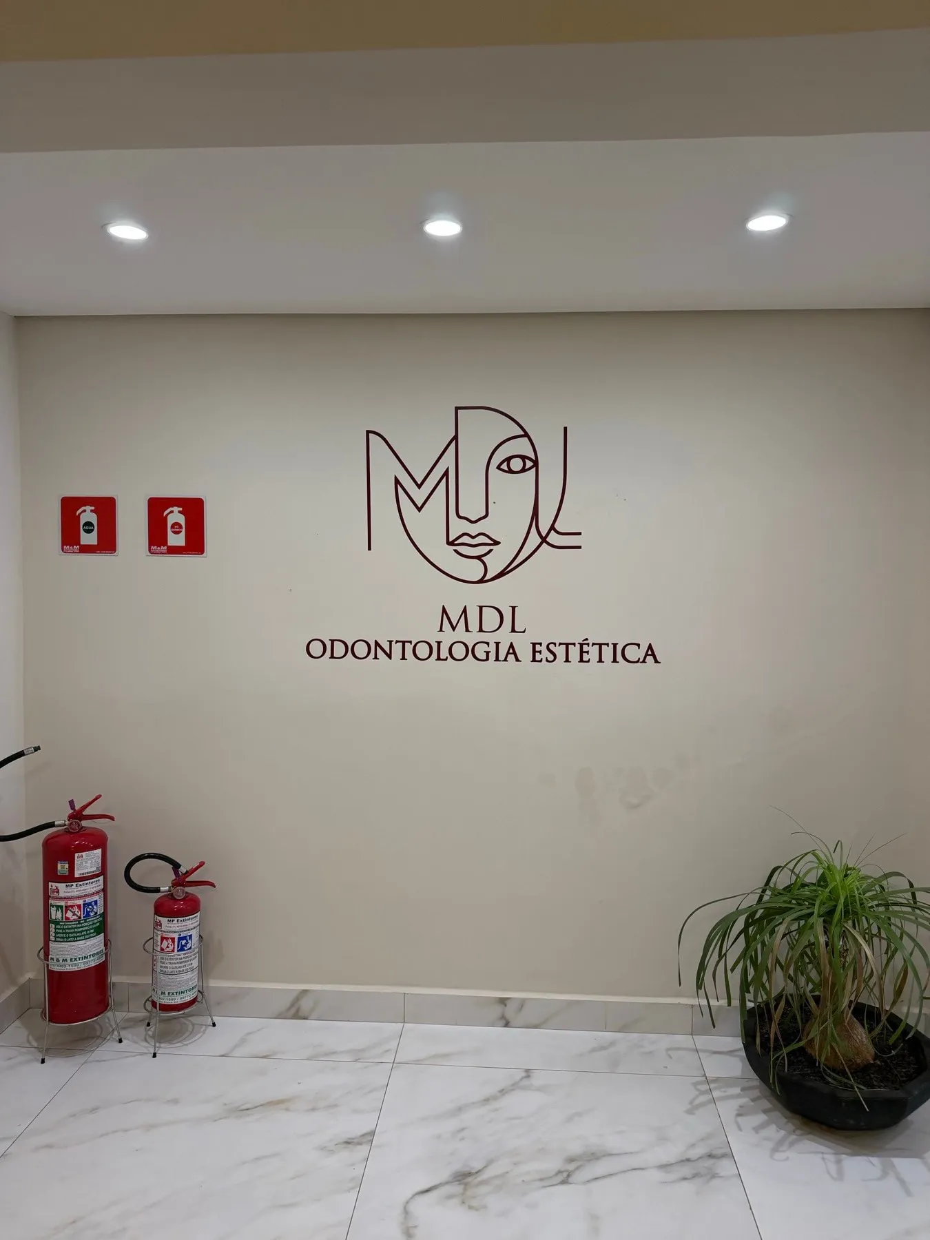 Logo MDL Odontologia Estética na parede interna da clínica em Atibaia